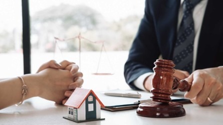 a gavel, home figurine, and a contract